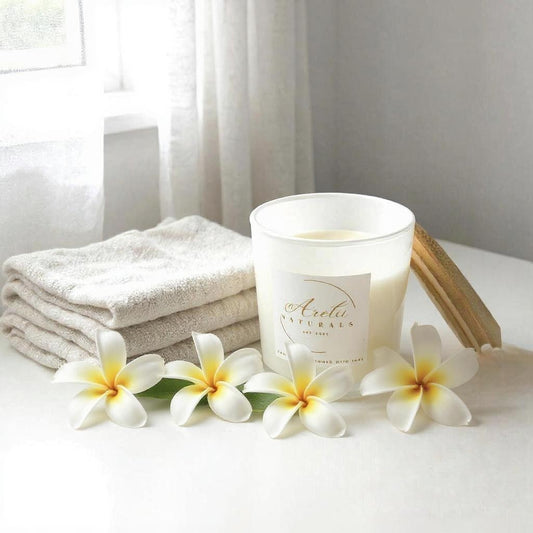 Aretii Coconut Frangipani coconut wax candle in white glass jar with white label and bamboo lid.